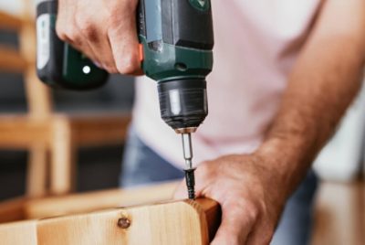 Using a drill to put a screw in wood.