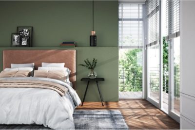A green bedroom with floor to ceiling windows.