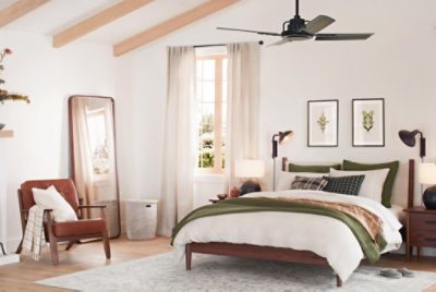 A neutral bedroom with vaulted ceilings, wood furntiure and white and green bedding.