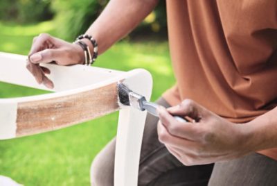 A person priming a patio chair.