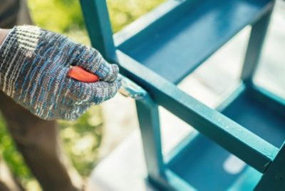 Person painting a table blue.