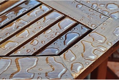 Close up of an outdoor table with water droplets on it.