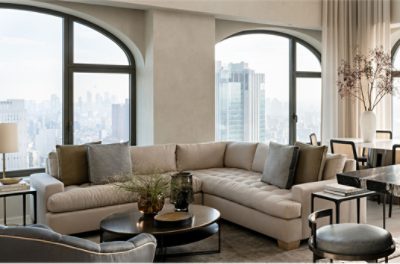 Large neutral living room with arched windows, sectional, side tables.