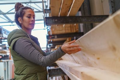 A person choosing boards at a lumber yard.