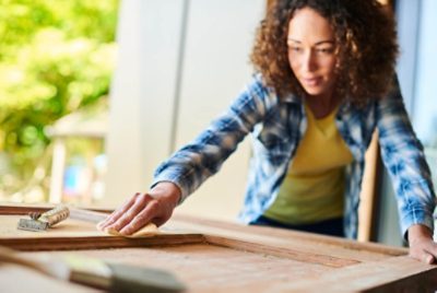 Woman prepping wood for staining.