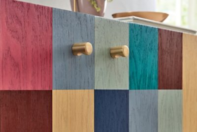 A wood dresser stained in a colorful checkered pattern.