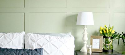 A bedroom with  light green painted batten walls. SW color featured: SW 6177 Softened Green.