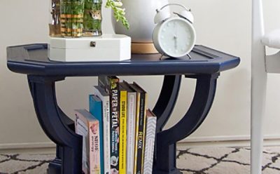 A navy blue end table with books and magazines. S-W color featured: SW 6244 Naval.