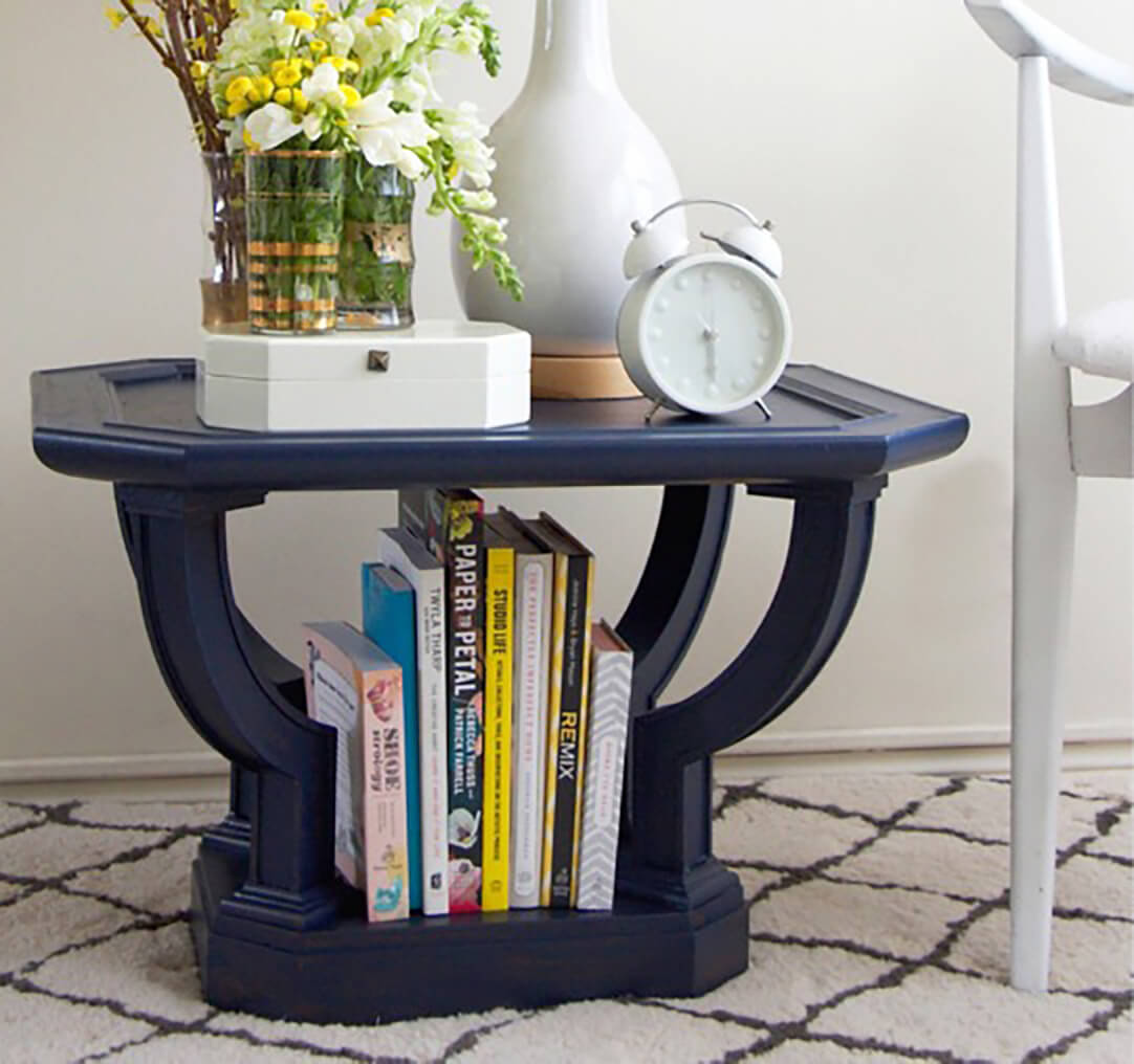 A navy blue end table with books and magazines. S-W color featured: SW 6244 Naval.