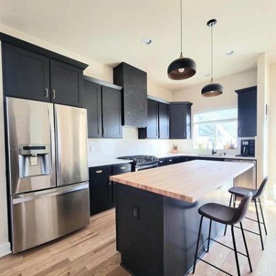A kitchen with cabinets painted black. S-W featured color: SW 6258 Tricorn Black.
