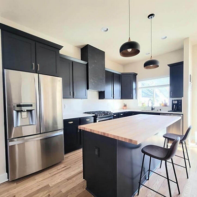 A kitchen with cabinets painted black. S-W featured color: SW 6258 Tricorn