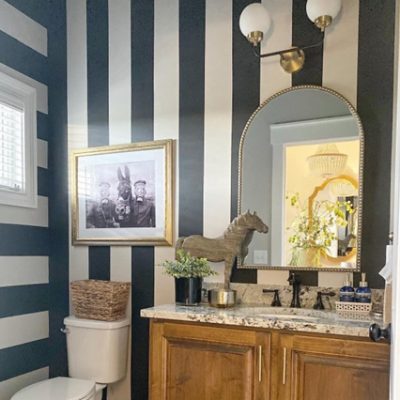 A bathroom vanity with vertical white and black stripes on the wall. S-W featured color: SW 6258 Tricorn Black