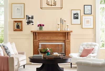 A traditional living room with white furniture, coffee table and vibrant yellow wall