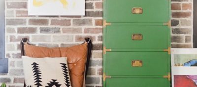 A dresser designed in a laminate paint arugula green with gold handle accents.