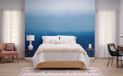A bedroom with a blue and white ombre accented wall. SW color featured: SW 6524 Commodore.