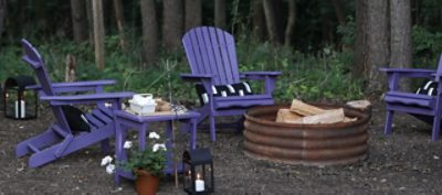 A set of wooden adirondack chairs painted in purple.