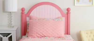 A headboard painted in dark pink trim with a painted light pink center.