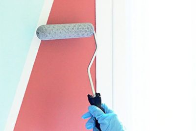 A coral and teal paint coating being applied to a sketchpad wall. SW color featured: SW 6606 Coral Reef, SW 6757 Tame Teal.