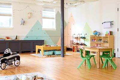 A playroom with white walls and multi-colored painted mountains. 