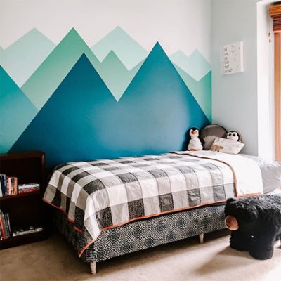 A bedroom backdrop with blue mountain murals. 