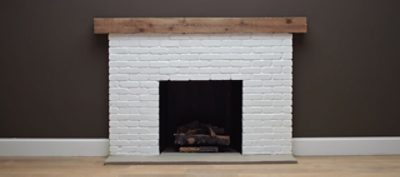 An extra white brick fireplace with dark brown painted walls. SW color featured: SW 7006 Extra White.
