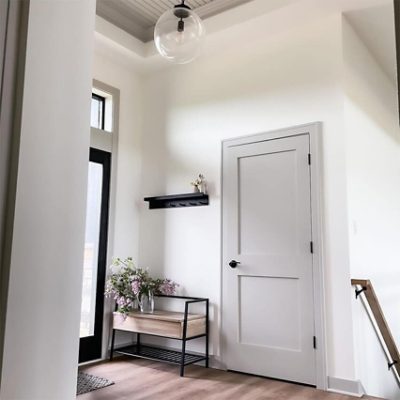 An indoor entryway with a gray painted door. S-W color featured: SW 7015 Repose Gray.