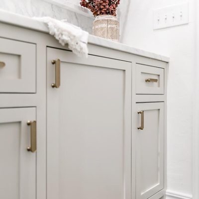 An offwhite dresser cabinet, neutral wall and hanging round mirror by @we3dwellingokc. S-W colors featured: SW 0050 Classic Light Buff.