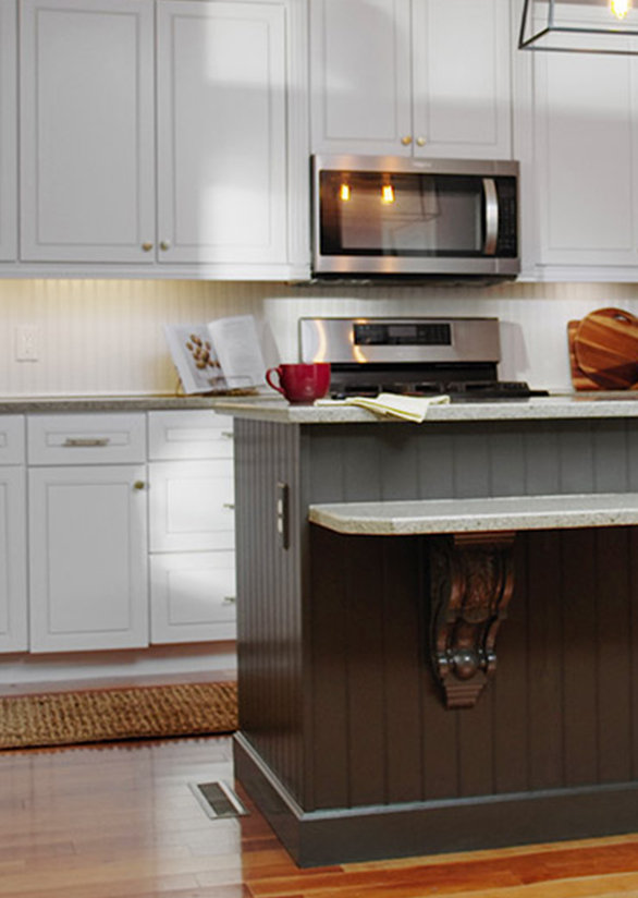 A kitchen with white cabinetry and hardwood floors. 