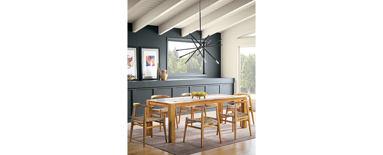 A cozy dining room with wood table, designer rug and gray wall. S-W colors featured: sw 7076 Cyberspace.