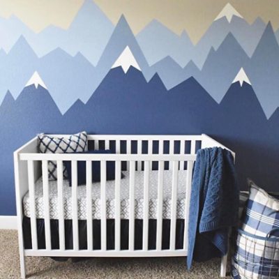 A bedroom with white and blue mountain murals. 