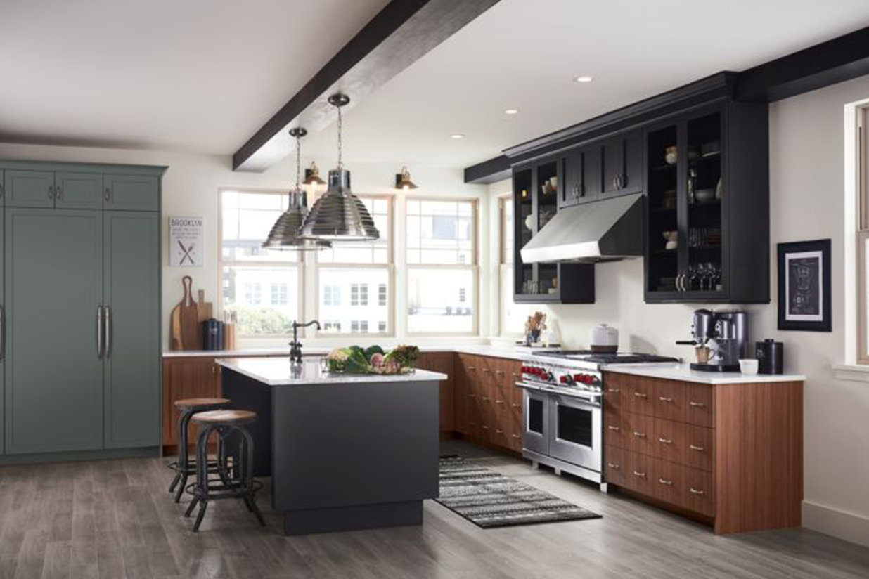 A kitchen with dark toned cabinets and hardwood floors. 