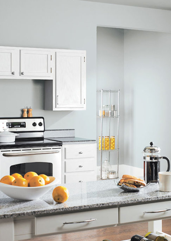 A kitchen with light gray walls and granite counter tops. 