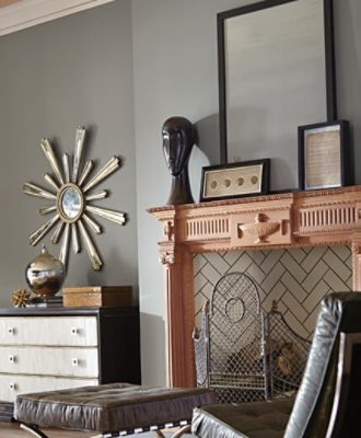An eclectic living room with fireplace, leather chair, and art decorations