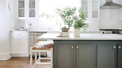 A white kitchen with a dark green kitchen island. 