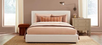 A bedroom with nude and orange bedding. SW colors featured: SW 9081 Redend.