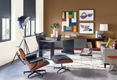 An orange and white home office with desk, furniture and wall art