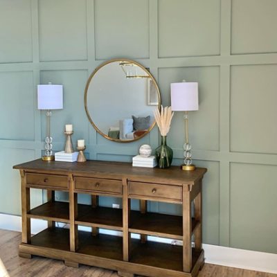 A bedroom with a vanity and  green painted batten walls. SW color featured: SW 9130 Evergreen Fog.
