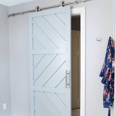 A light blue closet barn door with white trim. S-W featured color: 9137 Niebla Azul.