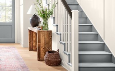 Bright grey stairway with white spindles and brown railing.