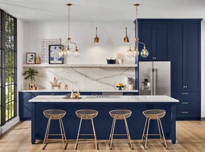 An open kitchen with navy island and cabinets, white walls and open shelves