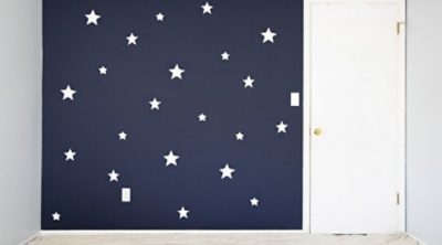 A navy painted wall with multiple white stars. 