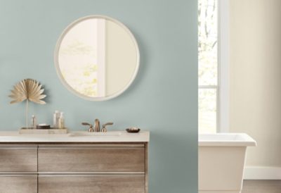 A spa-like bathroom with flatbottom tub, sink and green wall