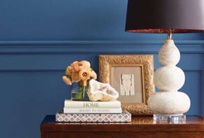 A deep blue wall with side table and books