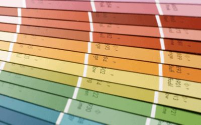 Sherwin-Williams color chips fanned out in rainbow order.