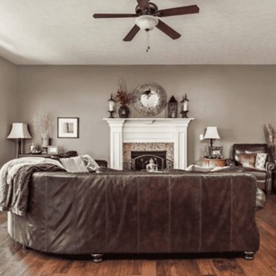 A living room with a large couch with walls painted in popular gray sw 6071 by @Islam.