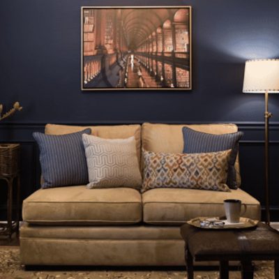 A living room with a love seat in front of a wall with a picture that is painted in naval sw 6244 by @dwellbycheryl.