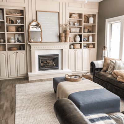 A large family room with built in book shelves and walls painted in kilim beige sw 6106 by @e.lynndesign.