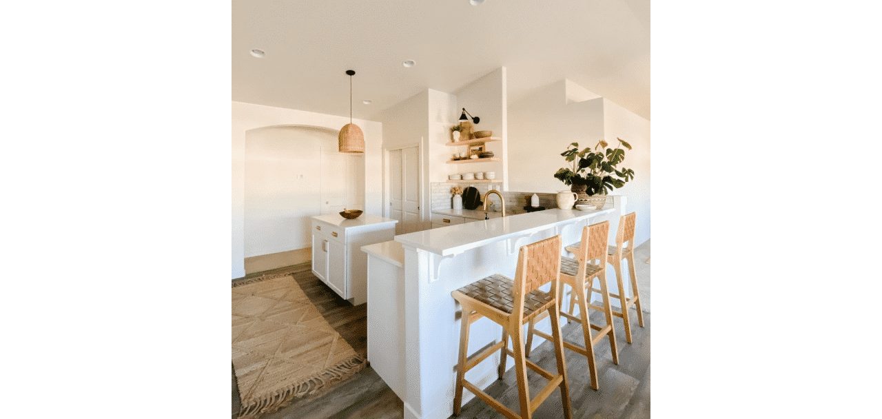 A kitchen with a a bar top and wooden bar chairs with walls painted in origami white sw 7636 by @fabulousatanystage.
