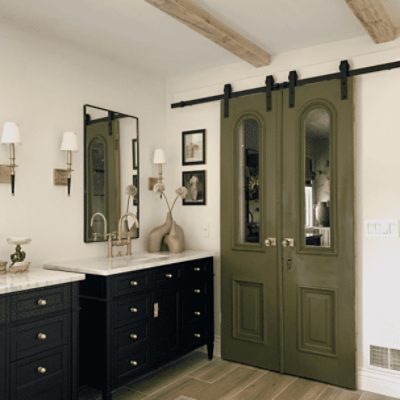 A large bathroom with green sliding doors and walls painted in pearly white sw 7009 by @haneens_haven.