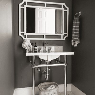 A bathroom with a white sink and mirror painted in peppercorn sw 7674 by @kristenlileinteriors.